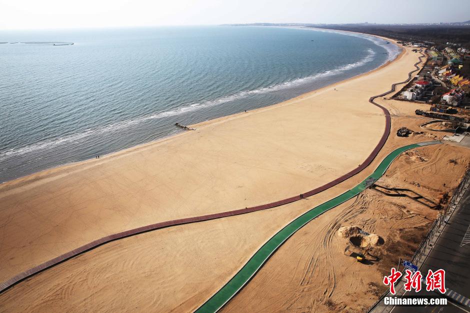 3月13日，秦皇島萬(wàn)米臨海沙灘木棧道。據(jù)了解，該木棧道全長(zhǎng)約4200米，與北戴河區(qū)原有的7500米木棧道對(duì)接后全線總長(zhǎng)度1.17萬(wàn)米，整個(gè)木棧道東起秦皇島體育基地游船碼頭，西至北戴河濕地公園，呈波浪形蜿蜒10.4公里海岸線。 中新社發(fā) 曹建雄 攝 CNSPHOTO